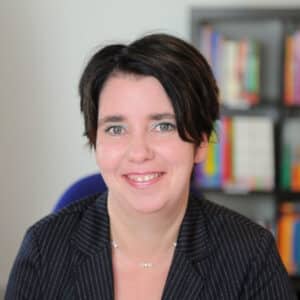 Eine Frau sitzt am Schreibtisch.