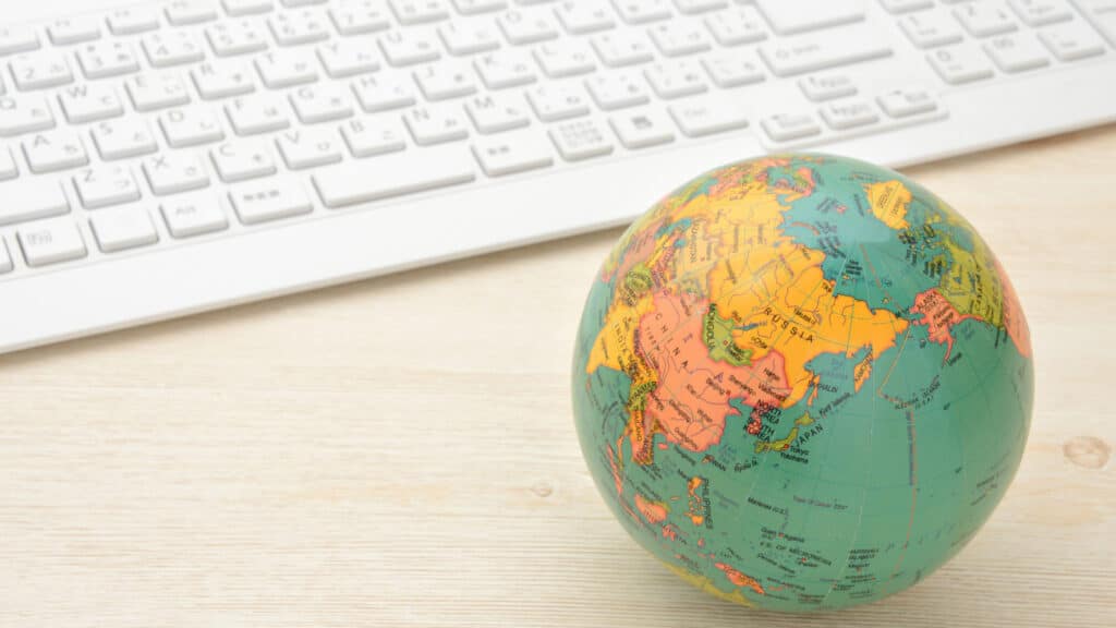 Eine Weltkugel liegt vor einer Tastatur.